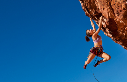 Female climber clinging to the edge.